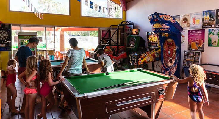 salle de jeux avec billards, jeux vidéos et fléchettes